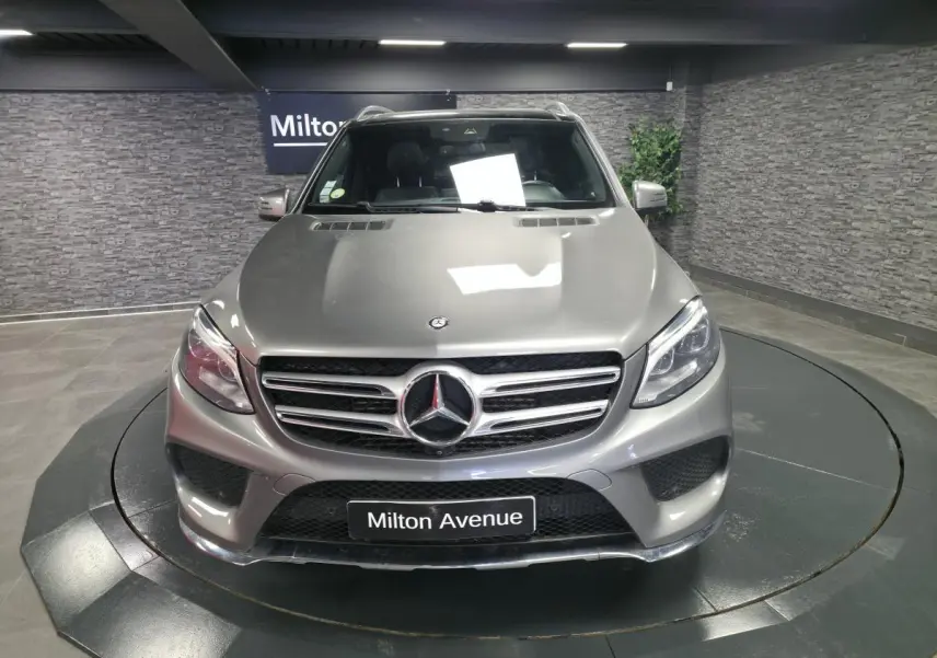 Vue avant d’un Mercedes GLE 350 d gris clair AMG Line, avec calandre chromée et logo étoile central.