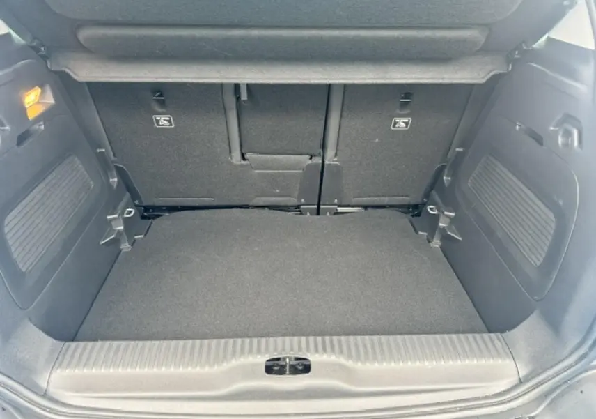 Coffre ouvert vu de face du Citroën C3 Aircross 2024, intérieur noir avec banquette arrière rabattable.