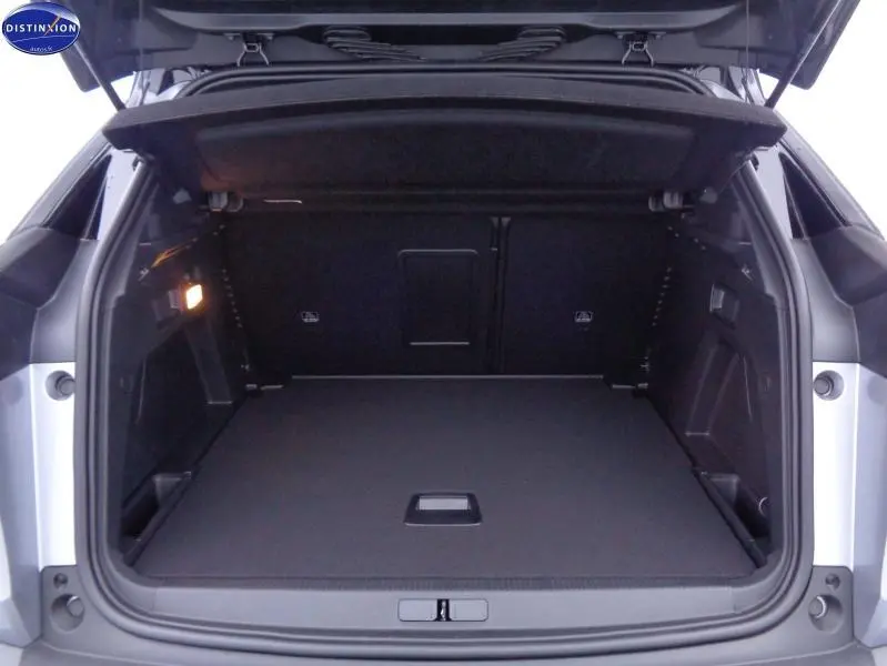 Coffre ouvert vu de l'arrière d'un Peugeot 3008 gris Artense, montrant un espace de chargement spacieux et bien éclairé.