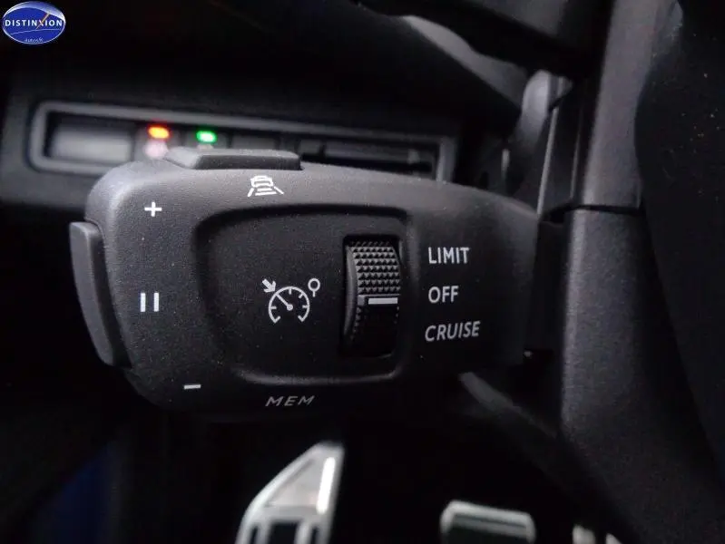 Gros plan sur la commande de régulateur de vitesse du Peugeot 3008 gris Artense, côté gauche du volant.