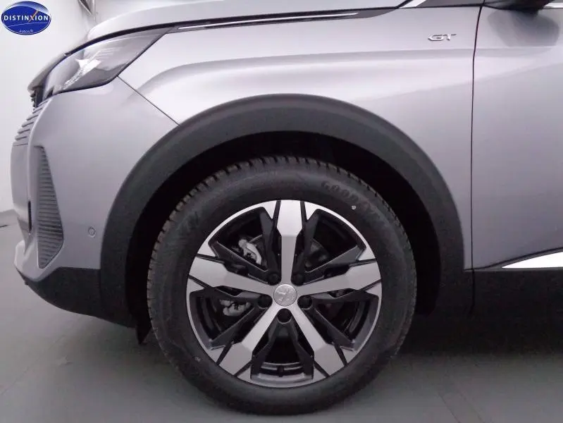 Gros plan sur la roue avant droite et l'aile gris Artense du Peugeot 3008 GT avec logo GT visible sur l'aile.