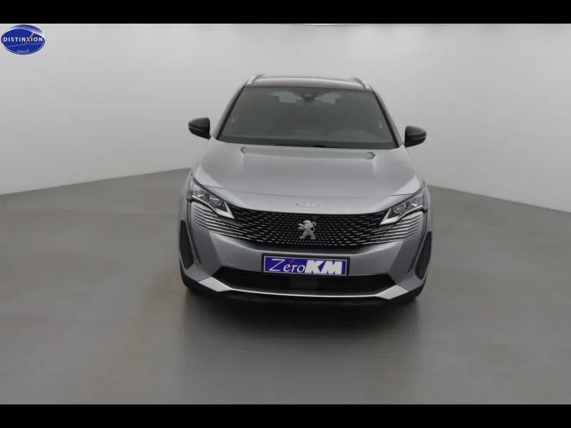 Vue frontale d'un Peugeot 3008 gris Artense avec calandre noire et logo lion au centre.