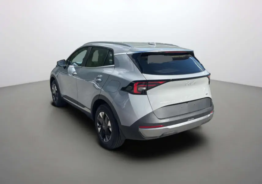 KIA Sportage 2026 gris céramique vu 3/4 arrière droit, feux arrière LED et jantes alu 17 pouces visibles.