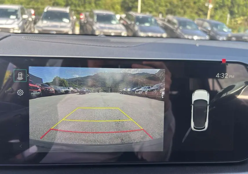 Écran de caméra de recul du Kia Sportage gris céramique montrant l'arrière avec lignes de guidage colorées.