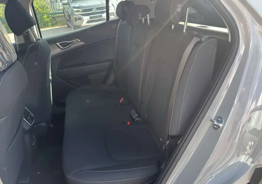 Vue intérieure côté droit sur la banquette arrière noire du Kia Sportage 2026 gris céramique avec ceinture de sécurité visible.