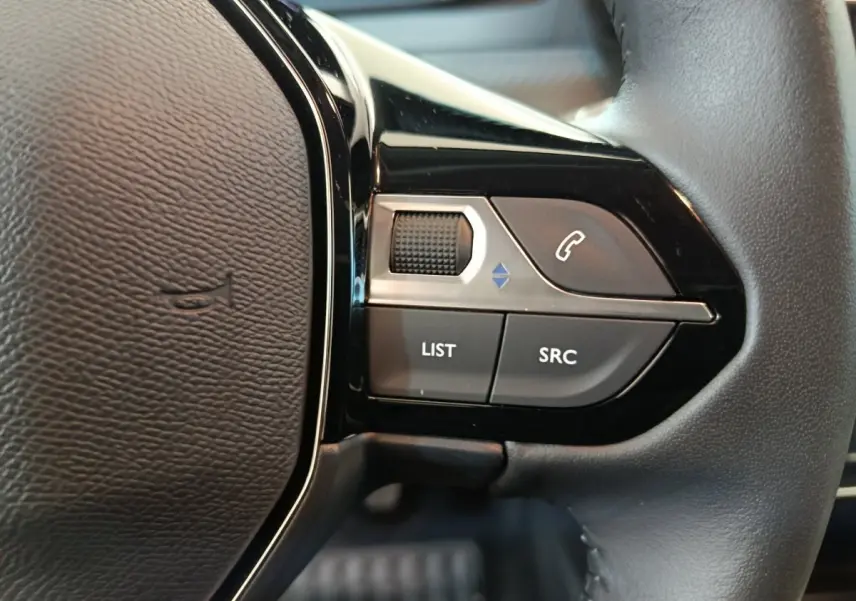 Gros plan sur les commandes gauche du volant cuir de la Peugeot 208 gris foncé PureTech 100 S&S Allure 2025.