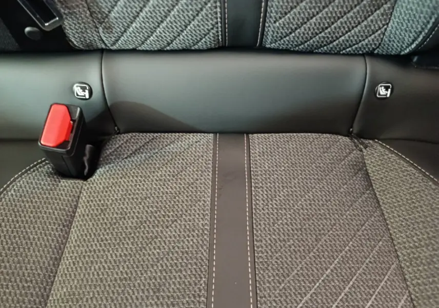Gros plan sur la banquette arrière gris foncé de la Peugeot 208 avec ceinture de sécurité rouge et fixation Isofix.