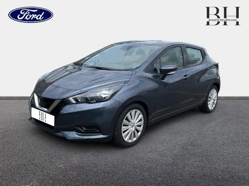 Nissan Micra gris acier vue 3/4 avant droit, avec jantes alliage et phares LED distinctifs.