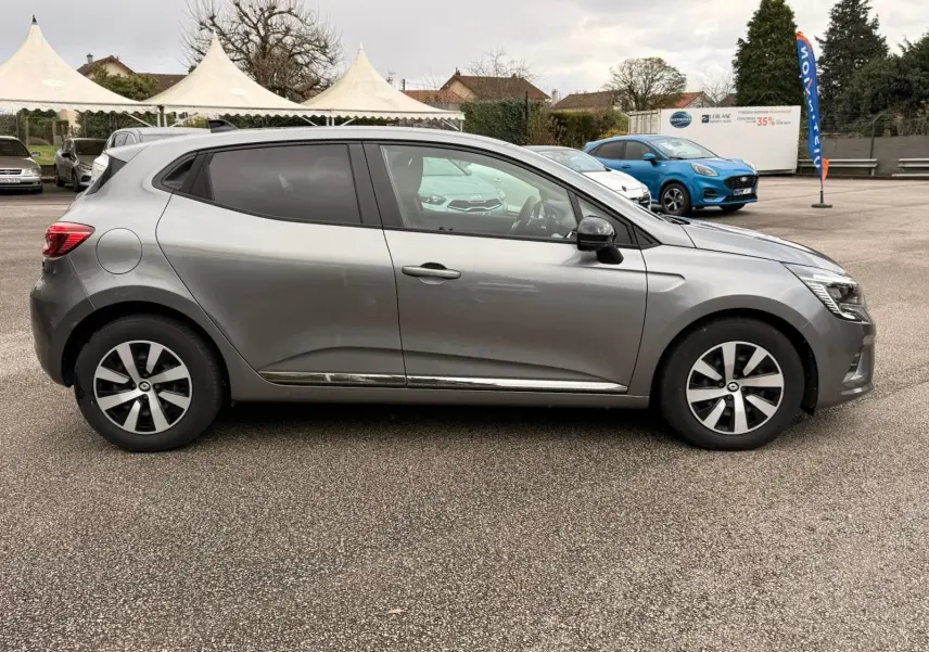 Renault Clio V gris schiste vue 3/4 avant droit, mettant en valeur ses phares LED et jantes bi-ton.