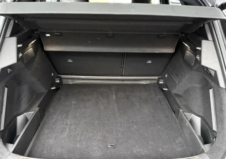 Coffre ouvert vu de l'arrière d'un DS7 gris titane, montrant un espace de chargement propre et bien agencé.