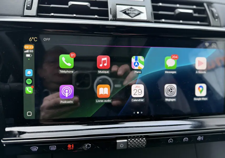 Écran tactile central du DS7 2025 affichant Apple CarPlay avec applications et commandes climatisation en dessous.