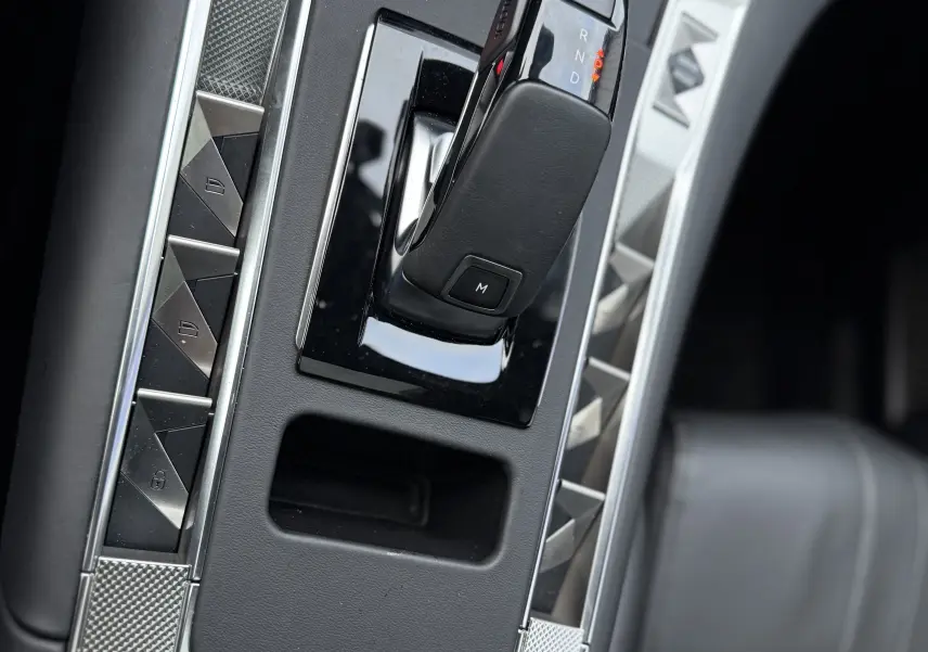 Gros plan sur la console centrale du DS7 2025, boîte auto noire avec finitions argentées et cuir noir visible.