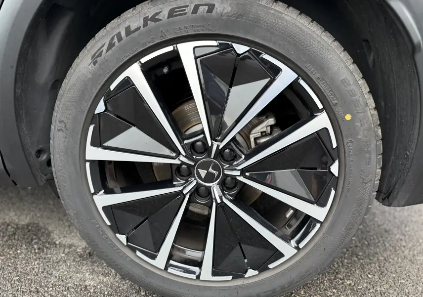 Gros plan sur la roue avant droite du DS7 2025 gris titane, jante alliage noir et argent au design géométrique.