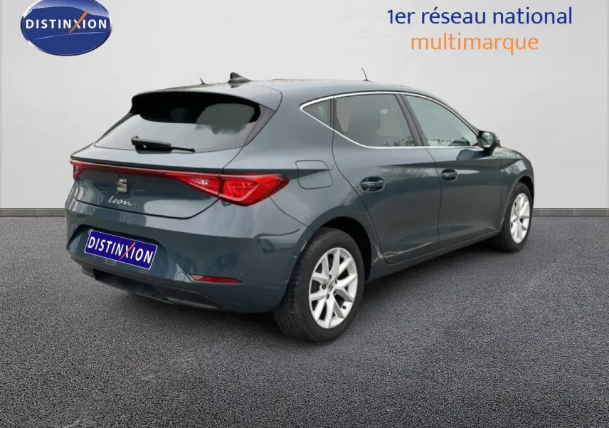 Vue 3/4 arrière droite d'une SEAT Leon 2025 bleu fjord avec feux arrière LED et jantes alliage argentées.