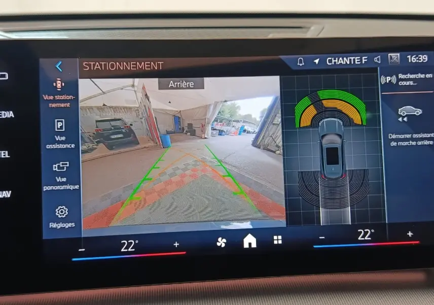 Écran tactile du système d'aide au stationnement montrant la vue arrière et les capteurs d'un BMW X1 gris foncé 2024.