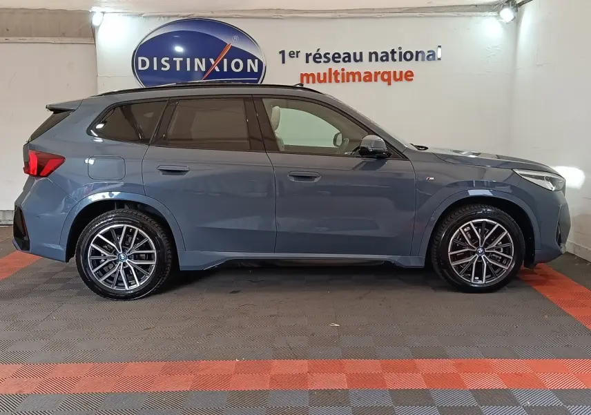 BMW X1 xDrive25e M Sport gris foncé vue de profil côté gauche, avec jantes alliage et vitres teintées.