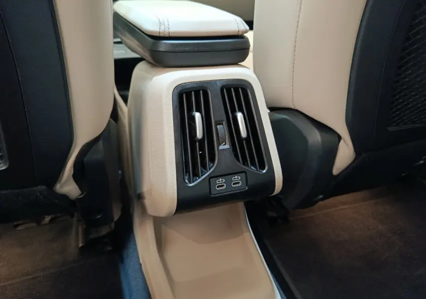 Vue rapprochée des aérateurs arrière et ports USB-C sur la console centrale beige du BMW X1 xDrive25e M Sport 2024.