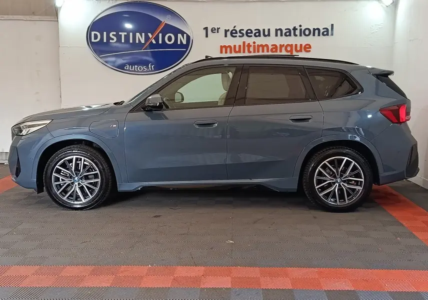BMW X1 xDrive25e M Sport gris foncé vue de profil côté gauche, avec jantes alliage et toit noir contrasté.