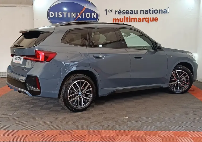 BMW X1 xDrive25e M Sport gris foncé vue de profil droit, avec jantes alliage et toit noir contrasté.