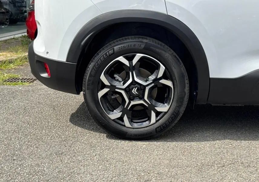 Gros plan sur la roue arrière droite d'un Citroën C5 Aircross blanc Okénite avec jante alu noire et argent.