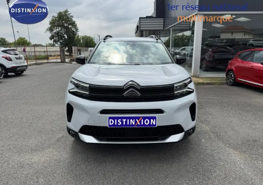 Vue avant d'un Citroën C5 Aircross blanc Okénite avec calandre noire et barres de toit visibles.