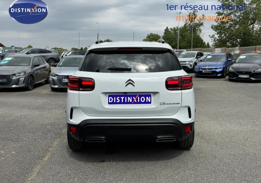 Vue arrière d'un Citroën C5 Aircross blanc Okénite avec feux arrière LED et barres de toit visibles.