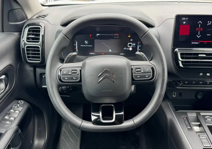 Vue intérieure centrée sur le volant cuir noir et le tableau de bord numérique du Citroën C5 Aircross 2025.