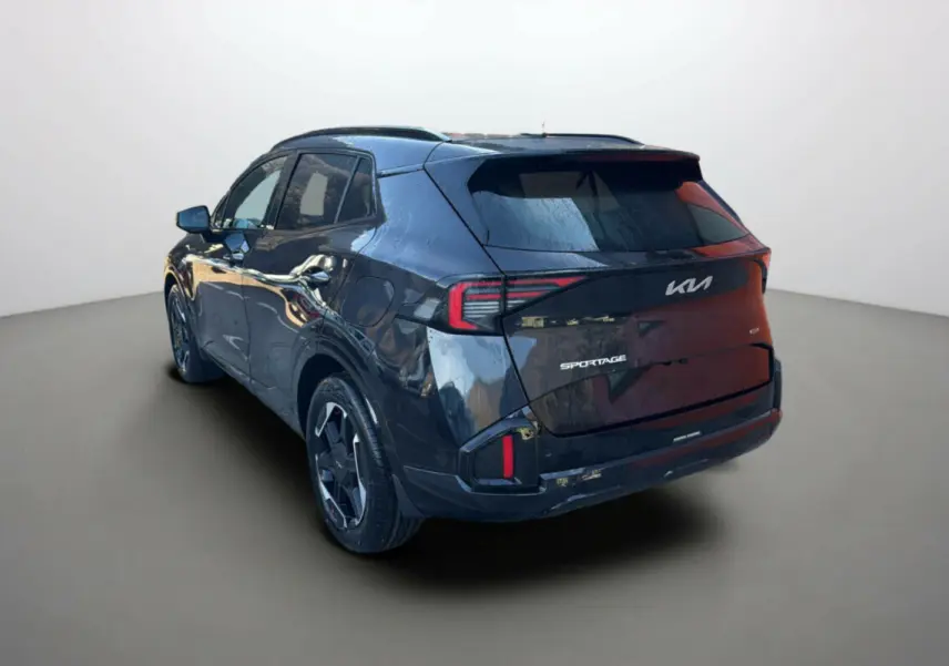 Vue 3/4 arrière gauche du KIA SPORTAGE noir étoilé avec feux arrière LED et jantes alu 19 pouces visibles.
