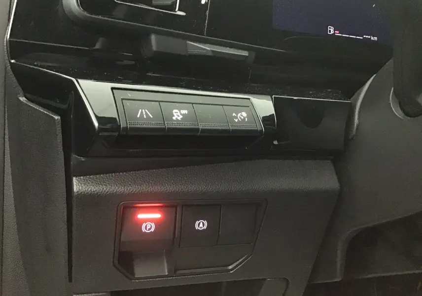 Détail des commandes du tableau de bord du Renault Austral 2023, avec bouton de frein à main électronique allumé.