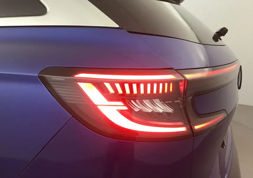Feu arrière droit allumé du Renault Austral 2023 bleu iron avec bandeau lumineux noir entre les feux.