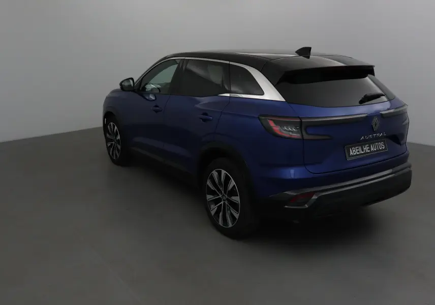 Renault Austral bleu Iron avec toit noir, vue 3/4 arrière côté gauche, jantes alliage et feux LED distinctifs.