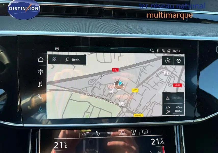 Écran tactile central de l'Audi A8 noir Sebring 2024 affichant la navigation et la climatisation à 21°C