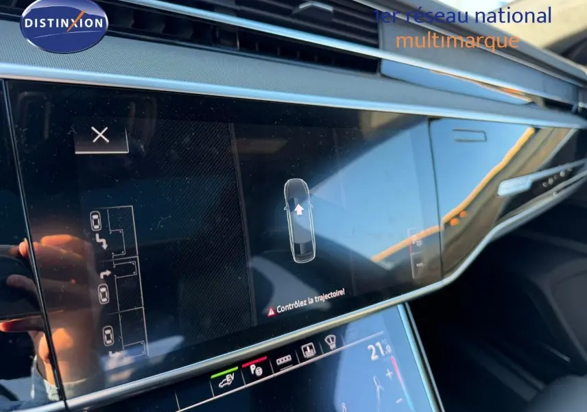 Vue rapprochée de l'écran tactile central de l'Audi A8 noire Sebring Cristal 2024, affichant l'aide au stationnement.