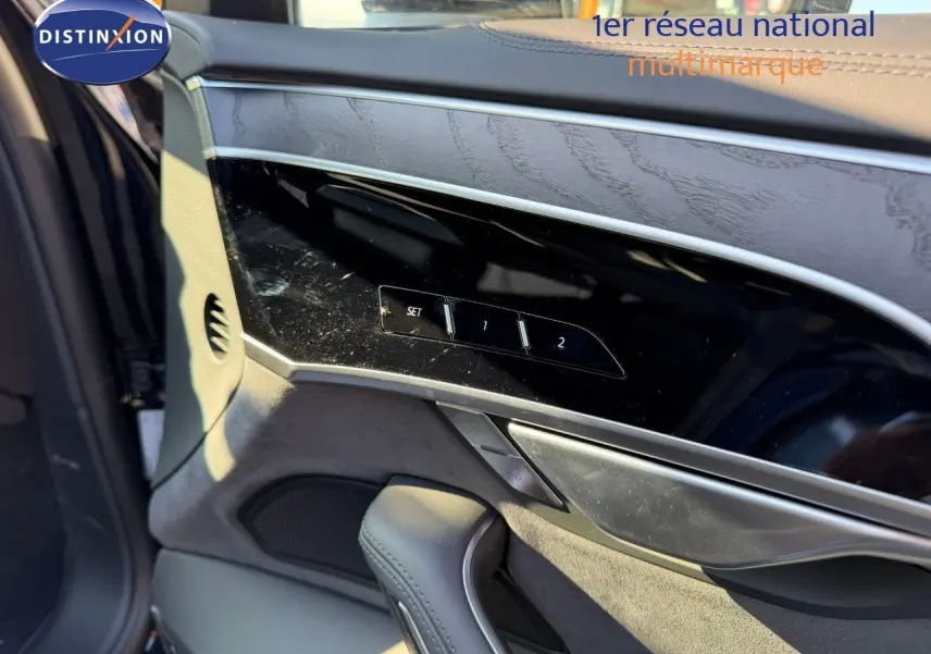 Détail de la porte côté gauche d'une Audi A8 2024 noire Sebring Cristal, avec commandes mémoire des sièges et garniture bois.