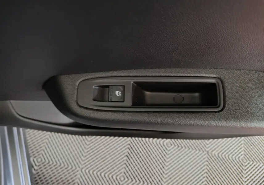 Bouton de commande de lève-vitre sur la porte intérieure côté conducteur d'une Renault Clio gris foncé 2025.