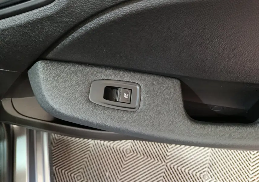 Bouton de commande de vitre électrique sur la porte intérieure côté conducteur d'une Renault Clio gris foncé 2025.