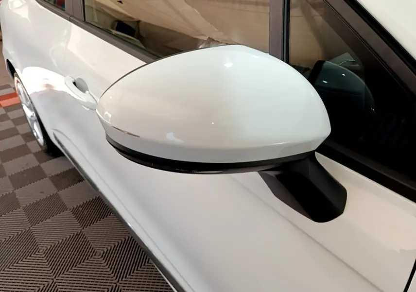 Gros plan sur le rétroviseur droit blanc d’une Renault Clio Business Blue dCi 115 de 2020, vue côté conducteur.
