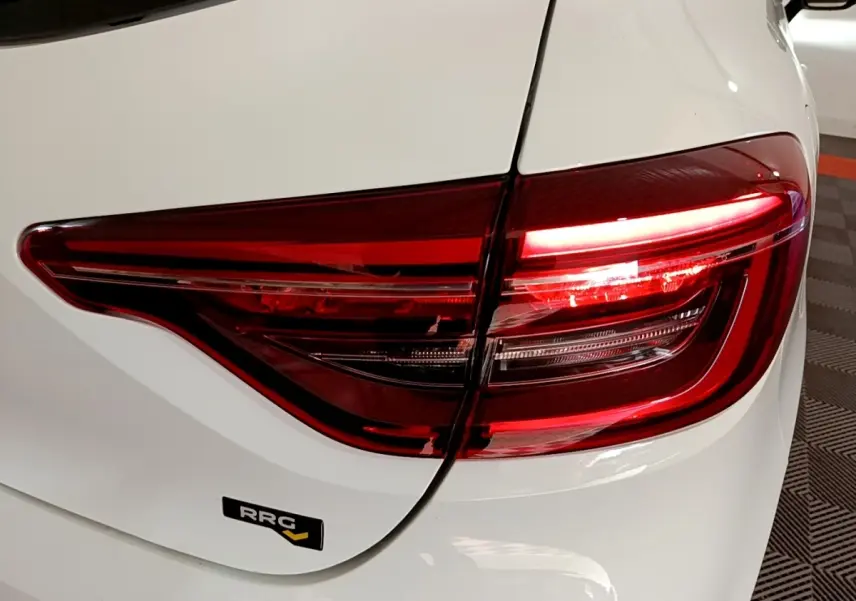 Gros plan sur le feu arrière droit rouge d'une Renault Clio Business Blue dCi 115 blanche, avec badge RRG visible.