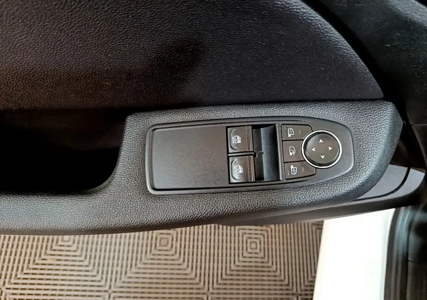 Gros plan sur les commandes électriques des vitres et rétroviseurs côté conducteur de la Renault Clio Business Blue dCi 115 2020.