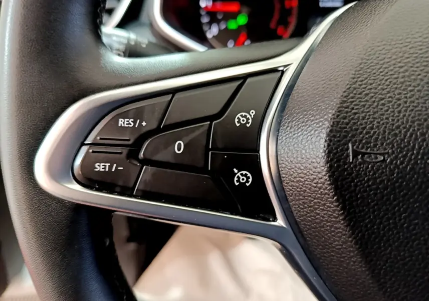 Gros plan sur les commandes de régulateur de vitesse au volant cuir noir de la Renault Clio Business 2020.