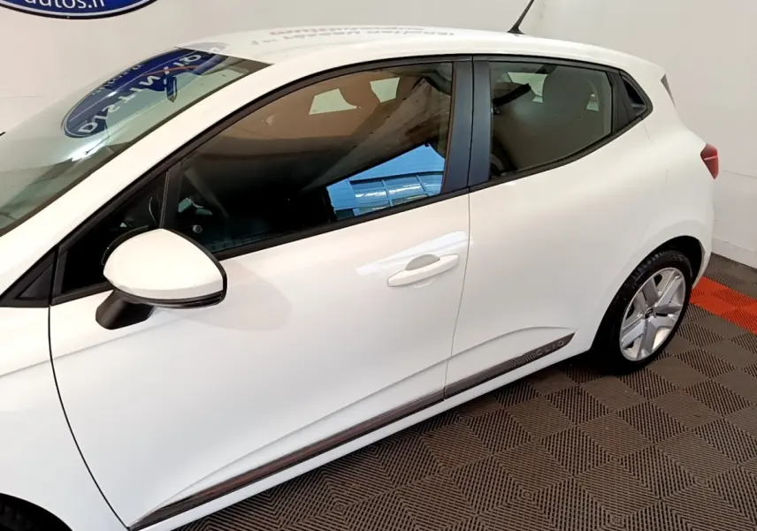 Vue latérale côté gauche d'une Renault Clio blanche Business Blue dCi 115 avec jantes alliage et rétroviseur blanc.