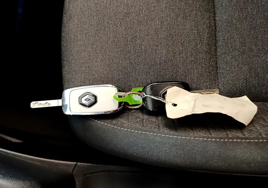 Clé de voiture Renault posée sur un siège tissu gris foncé à l'intérieur d'une Renault Clio blanche 2020.