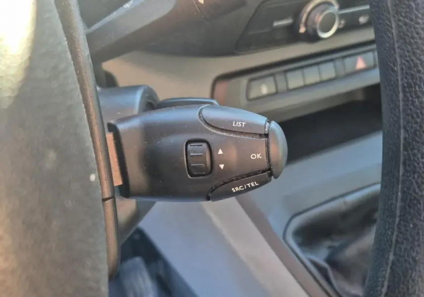 Gros plan sur la commande au volant du Citroën Jumpy blanc, version fourgon L1H1, montrant les boutons LIST, OK et SRC/TEL.