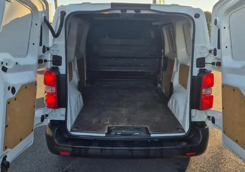 Vue arrière ouverte du fourgon blanc Citroën Jumpy L1H1 2019, montrant l’espace de chargement vide et les portes battantes.