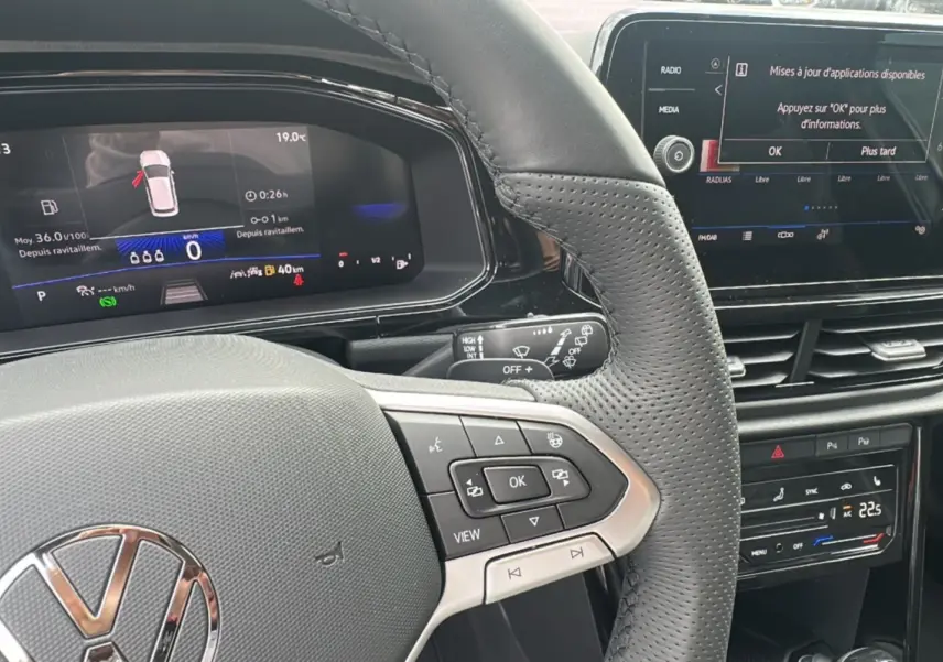 Vue rapprochée du volant cuir multifonctions et du tableau de bord digital du Volkswagen T-Roc gris pyrite 2025.