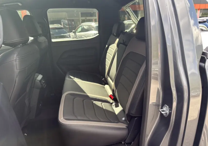 Vue intérieure côté droit sur les sièges arrière cuir noirs du Volkswagen Amarok Simple Cabine gris foncé 2026.