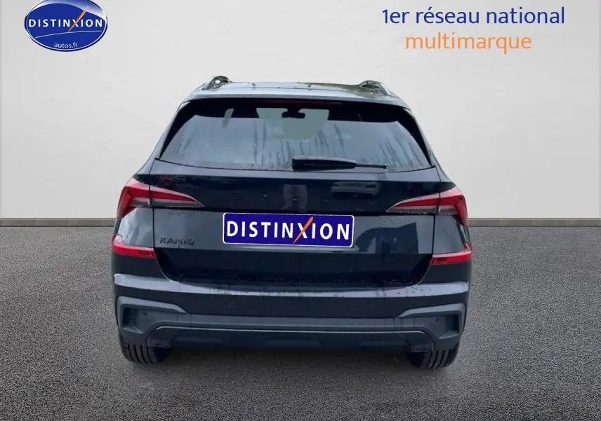 Vue arrière d'un Skoda Kamiq noir 2026 avec feux LED et barres de toit visibles sur fond clair.