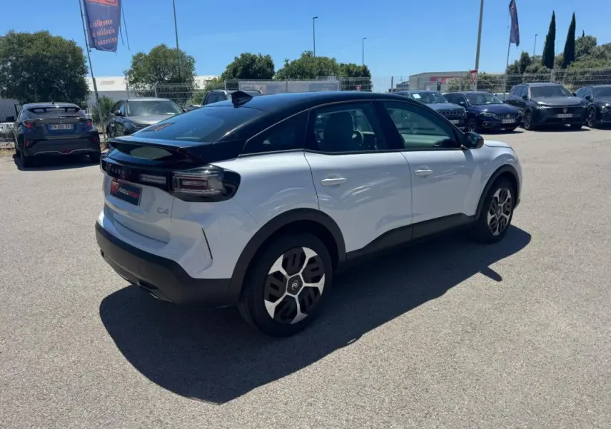 Citroën C4 hybride blanc vue 3/4 arrière droit, toit noir, jantes alliage 18 pouces et feux arrière distinctifs.