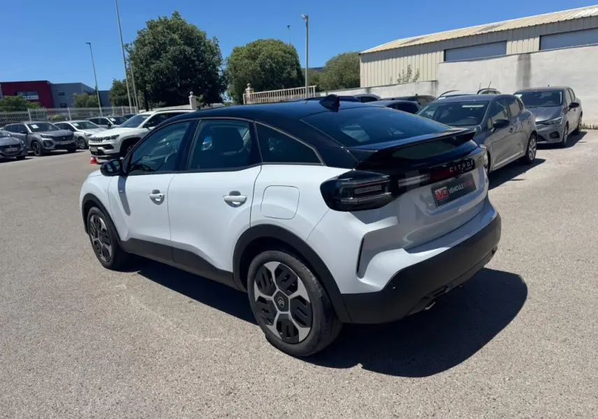Citroën C4 hybride blanc vue 3/4 arrière droit avec toit noir et jantes alliage 18 pouces.