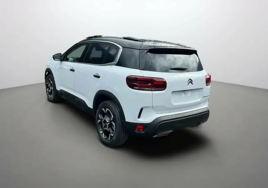 Vue 3/4 arrière droite d'un Citroën C5 Aircross blanc okénite avec toit noir et jantes alu 18 pouces.